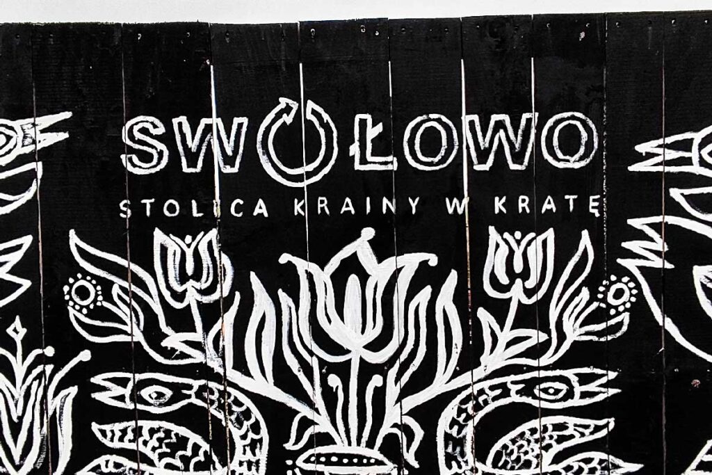 Napis na drewnianych belkach Swołowo stolica krainy w kratę
